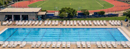 Vista aérea da piscina do clube com espreguiçadeiras ao redor e pista de caminhada ao lado